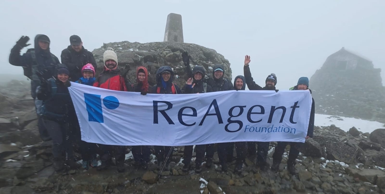 One of the Three Peaks Challenge highlights - the team at the top of Ben Nevis holding the ReAgent Foundation banner.